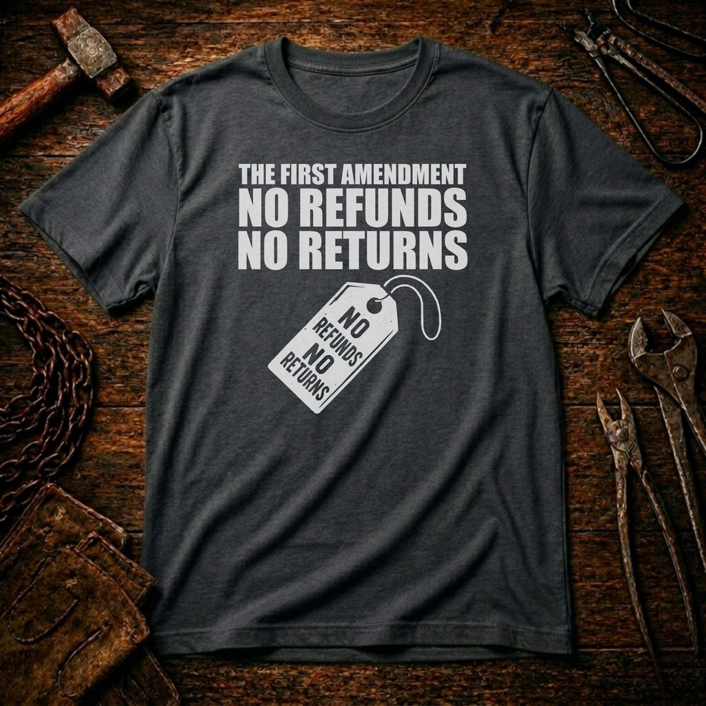 Gray t-shirt with 'The First Amendment: No Refunds, No Returns' text on a rustic wooden background.