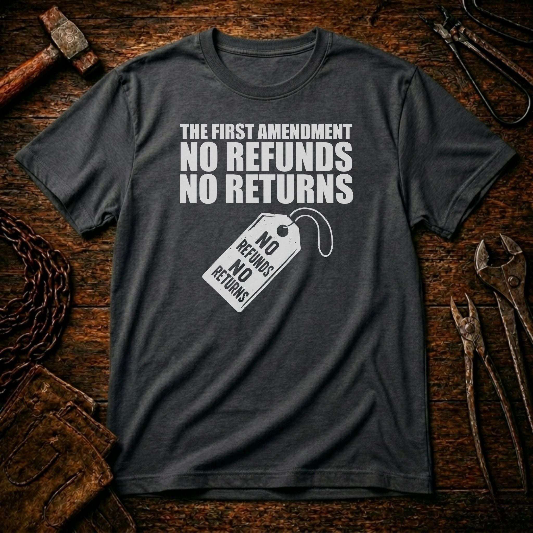 Gray t-shirt with 'The First Amendment: No Refunds, No Returns' text on a rustic wooden background.