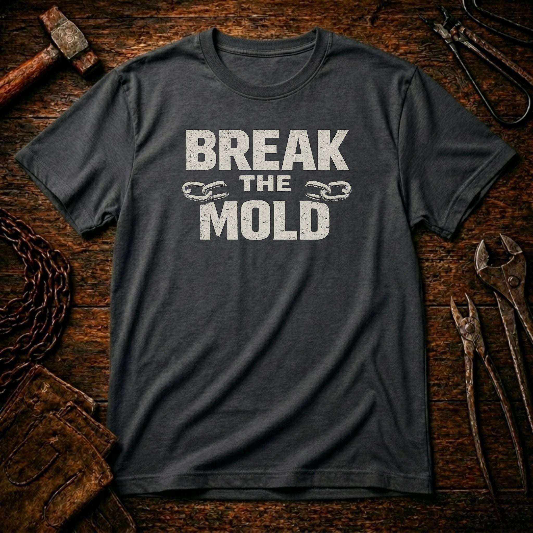 Gray t-shirt with 'Break The Mold' text on a rustic wooden background
